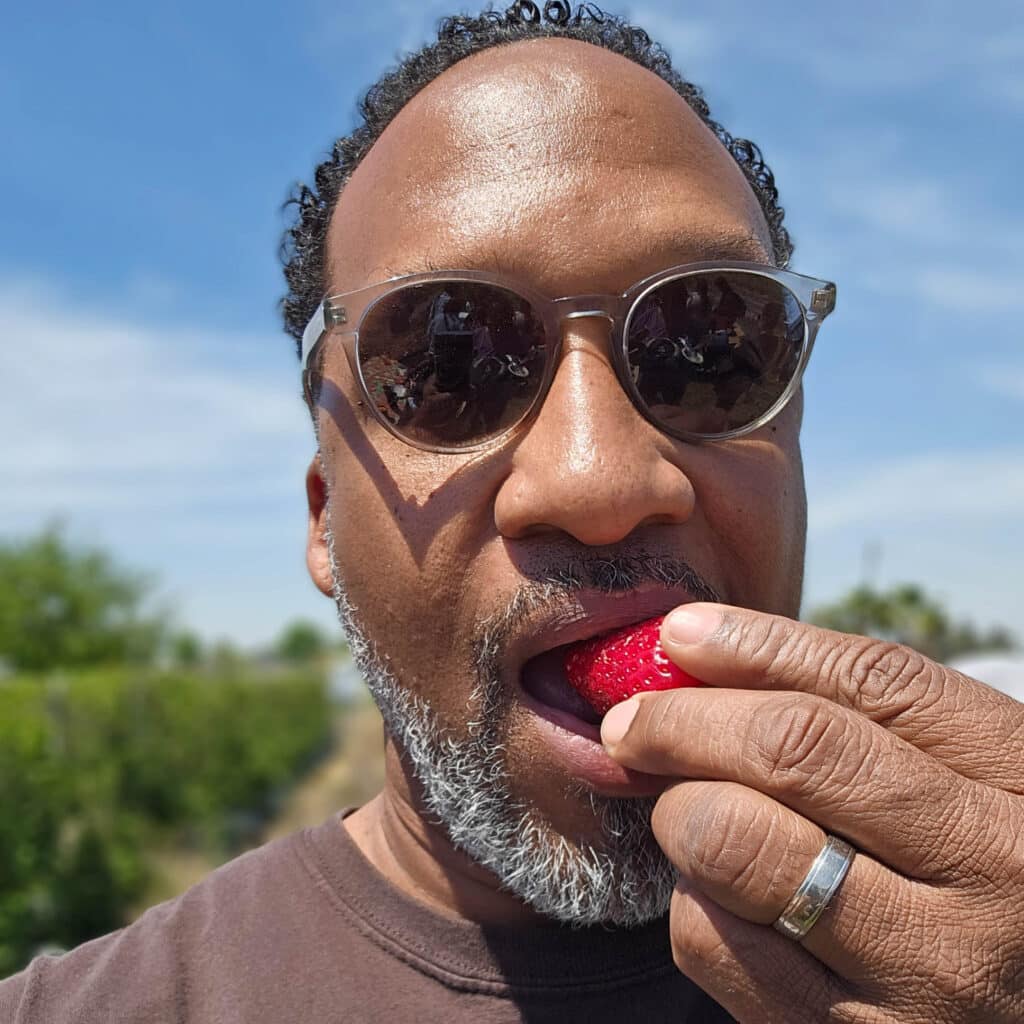 Sipp Culture co-director Carlton Turner takes a bite of a fresh California strawberry